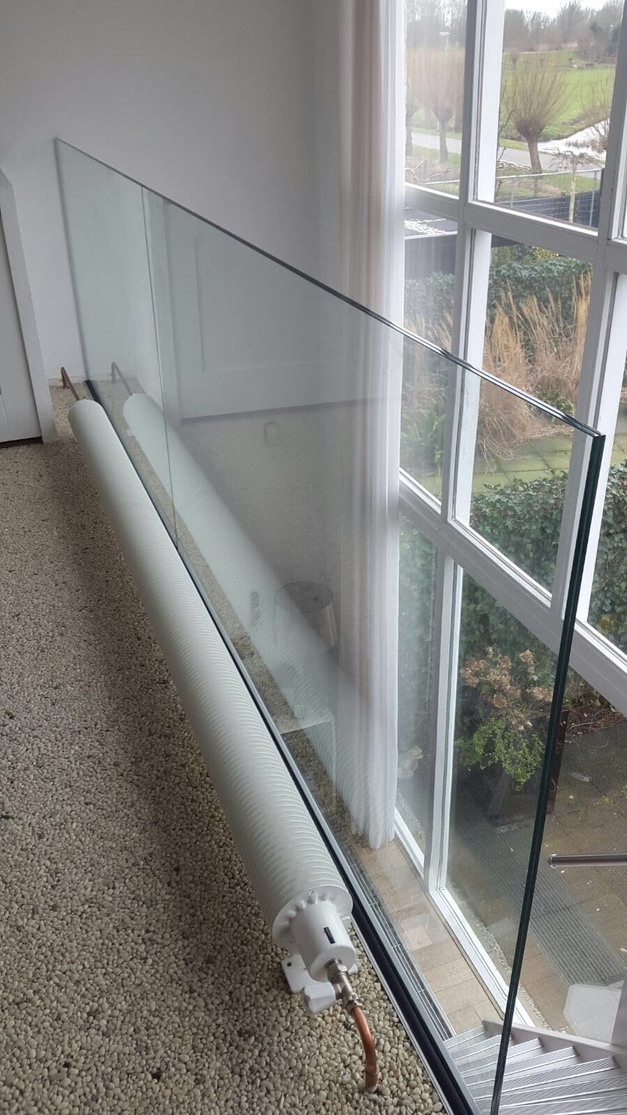 Glazen balustrade die uit de vloer lijkt te komen op verdieping